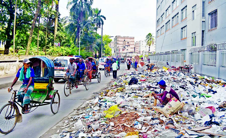 Waste and garbage dumped on many city streets still remain unattended turning the city into breeding grounds of mosquitoes. This photo was taken from near the entrance of Sheikh Hasina National Burn and Plastic Surgery Institute in Dhaka on Monday.