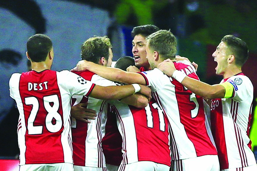Ajax players celebrate scoring their side's third goal during the group H Champions League soccer match between Ajax and LOSC Lille at Johan Cruyff ArenA in Amsterdam, Netherlands on Tuesday.
