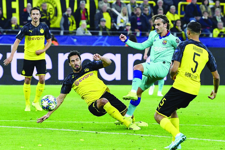 Barcelona's Antoine Griezmann ( second right) attempts a shot at goal in front of Dortmund's Mats Hummels during the Champions League Group F soccer match between Borussia Dortmund and FC Barcelona in Dortmund, Germany on Tuesday.
