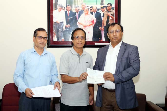 Abdur Raqib, on behalf of sons and daughter of late Abdul Moktader, hands over a cheque for Tk. 5 lac to Dhaka University Treasurer Prof Dr Md. Kamal Uddin at the latter's office on Tuesday to enhance the capital 'Professor Abdul Moktader Scholarship Tr