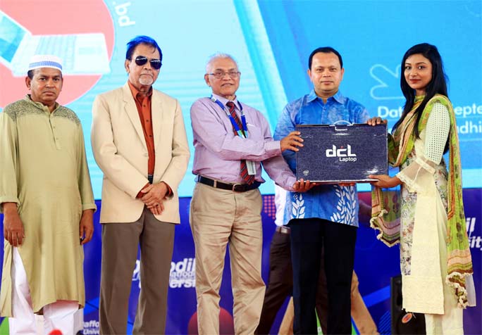 Former Vice Chancellor of Daffodil International University Emeritus Professor Prof Dr M Lutfar Rahman distributes laptops among the students of the University at its Ashulia campus on Wednesday. Dr Md. Sabur Khan, Chairman, Board of Trustees of the Unive