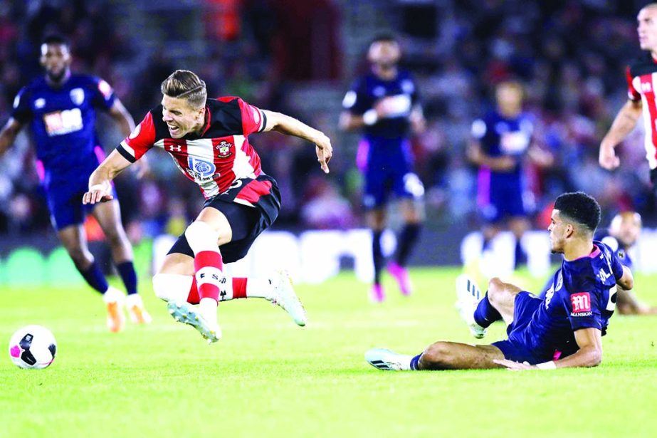 Southampton's Jan Bednarek (left) is challenged by Bournemouth's Dominic Solanke during the English Premier League soccer match between Southampton and Bournemouth at St Mary's stadium in Southampton, England on Friday.