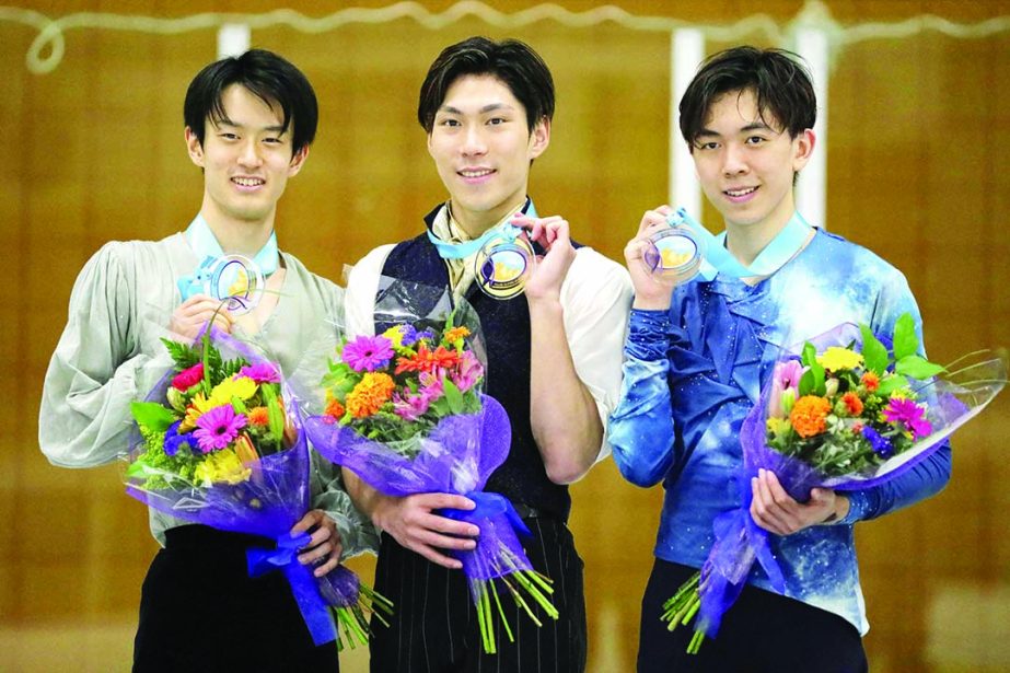 First-place finisher Keiji Tanaka (center) shares the podium with second-place Sota Yamamoto (left) both of Japan, and third-place finisher Vincent Zhou (right) of the United States, following the men's competition at the U.S. International Figure Skatin