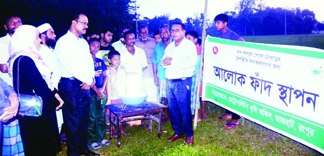 RANGPUR: Deputy Director of the DAE Dr. Md. Sarwarul Haque demonstrating the process of setting up light trap and perching methods to farmers for pests managements in growing T-Aman rice fields at a function on Friday evening in the district.