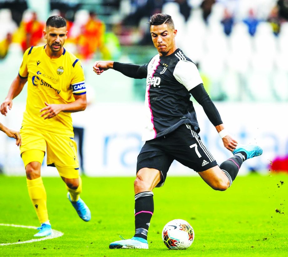 Juventus' Portuguese forward Cristiano Ronaldo (right) shoots on goal during the Italian Serie A football match between Juventus and Verona, at the Juventus stadium in Turin on Saturday.
