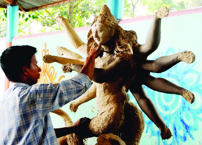 BOGURA: Idols maker passing busy time at a Puja mandap in Bogura yesterday.