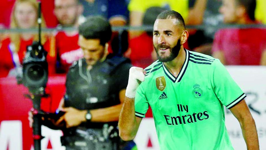A towering header from Karim Benzema gave Real Madrid an impressive 1-0 win at Sevilla to go level on points at the top of La Liga on Sunday.