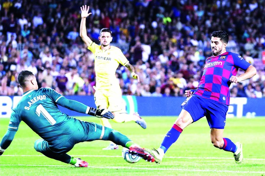 Barcelona's Luis Suarez (right) tries to beat Villareal's goalkeeper Sergio Asenjo during the Spanish La Liga soccer match between FC Barcelona and Villarreal CF at the Camp Nou stadium in Barcelona, Spain on Tuesday.