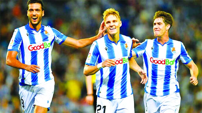Real Sociedad's Martin Odegaard (center) celebrates with teammates Mikel Merino and Aritz Elustondo (right) after a goal of their team during the Spanish La Liga soccer match between Real Sociedad and Alaves at Reale Arena stadium, in San Sebastian, nort