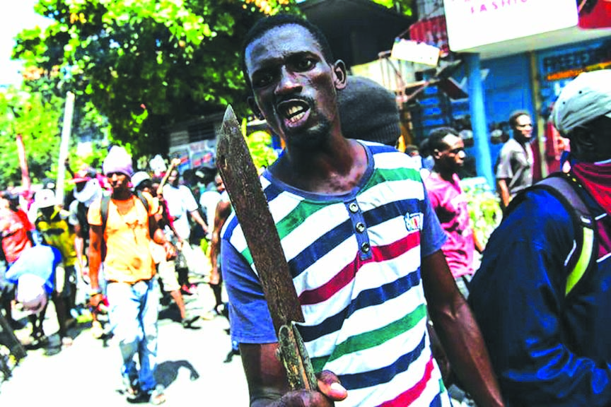 A demonstrator marches to demand the resignation of President Jovenel Moise, in Port-au-Prince on Friday.