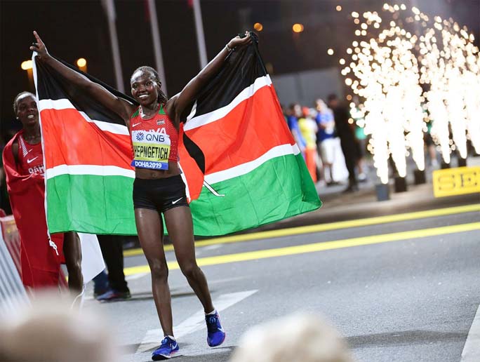 Ruth Chepngetich of Kenya, poses with the national flag after winning gold medal in the women's marathon of the World Athletics Championships in Doha, Qatar on Saturday.