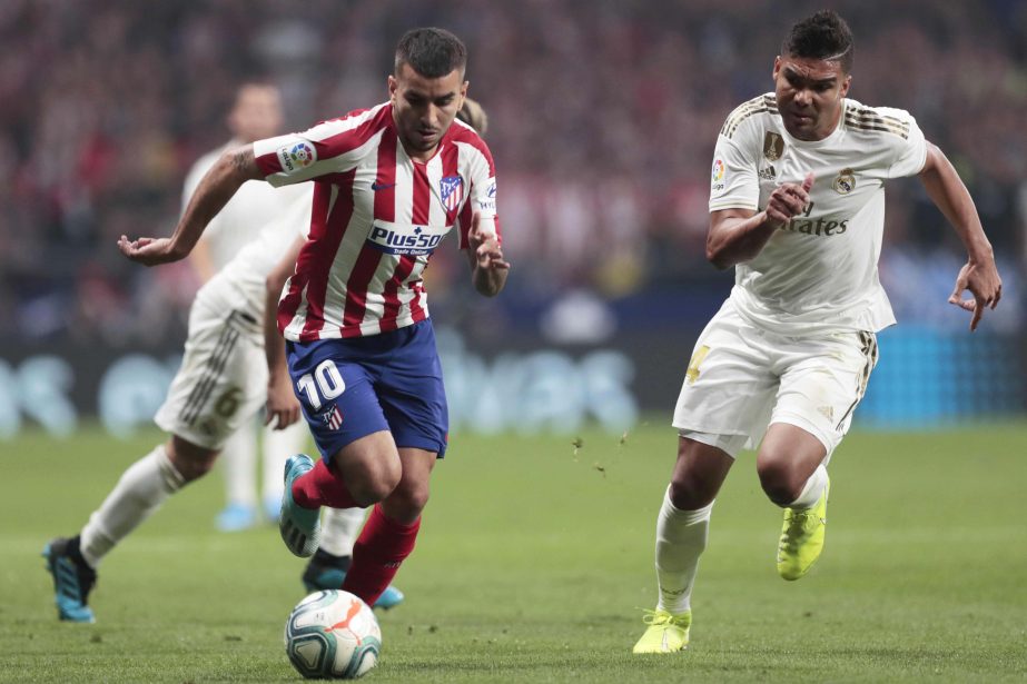 Atletico Madrid's Angel Correa( left) and Real Madrid's Casemiro vie for the ball during the Spanish La Liga soccer match between Atletico Madrid and Real Madrid at the Wanda Metropolitano stadium in Madrid on Saturday.
