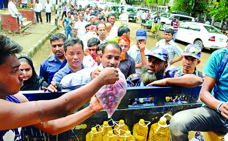People queue up to buy onions at Tk 45 per kg, sold by the Trading Corporation of Bangladesh. This photo was taken from a sales point set up in front of Bangladesh Secretariat on Monday.