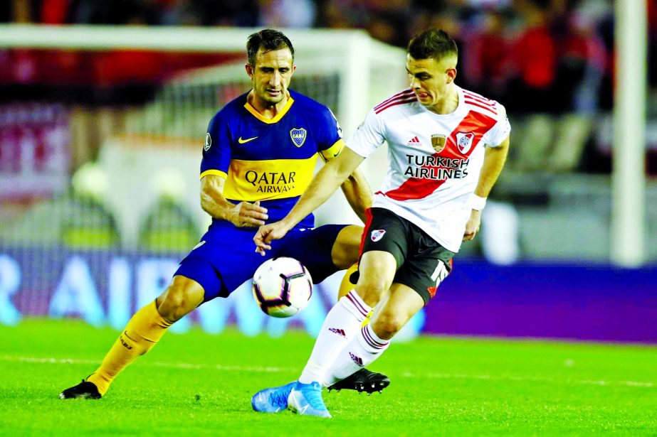 Exequiel Palacios (right) of Argentina's River Plate is challenged by Carlos Izquierdoz of Argentina's Boca Juniors during a Copa Libertadores semifinal first leg soccer match at the Monumental Antonio Vespucio Liberti stadium in Buenos Aires , Argentin