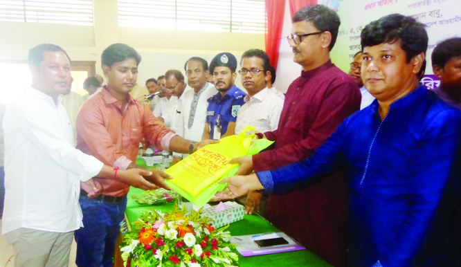 BIRAL (Dinajpur): State Minister for Shipping Ministry Khalid Mahmud Chowdhury MP distributing money among the mandabs at Biral Upazila as Chief Guest on Friday.