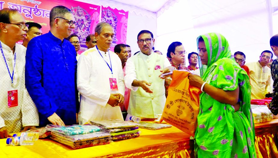 Minister for Roads and Bridges Obaidul Quader MP distributing clothes on the occasion of Durga Puja at Dhakeshwari Temple in the Old Dhaka yesterday .