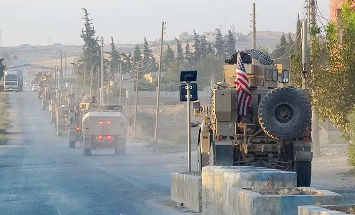 U.S. military vehicles travel down a main road in northeast Syria on Monday,