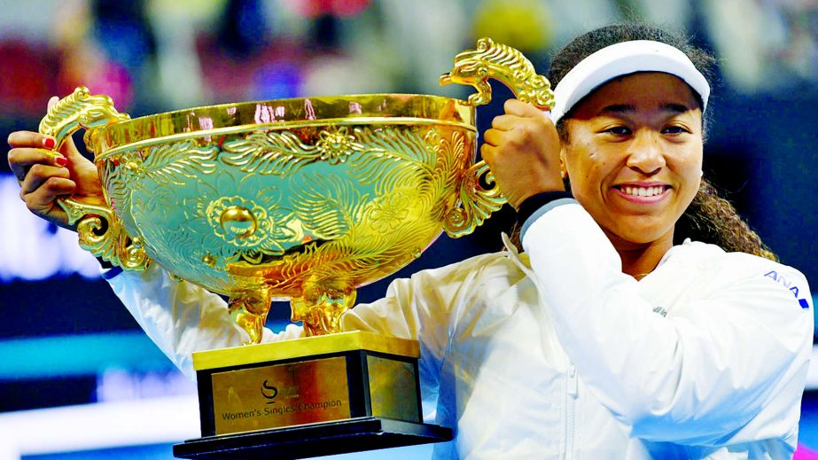 Naomi Osaka of Japan poses with the trophy after winning her women's singles final match against Ashleigh Barty of Australia at the China Open tennis tournament in Beijing on Sunday.