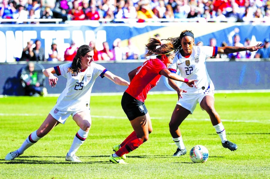 South Korea midfielder Cho So Hyun(center)looks to kick the ball away from United States midfielder Andi Sullivan(left) and forward Jessica McDonald(right) during the second half of an international friendly soccer match in Chicago on Sunday.