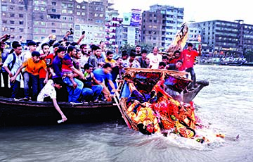 Hindu devotees bid farewell to the Goddess Durga through immersion of her idol in the River Buriganga in Dhaka on Tuesday.