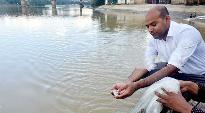 Upazila Nirbahi Officer of Hathazari Md. Ruhul Amin releasing fish fry in Halda river on Tuesday.