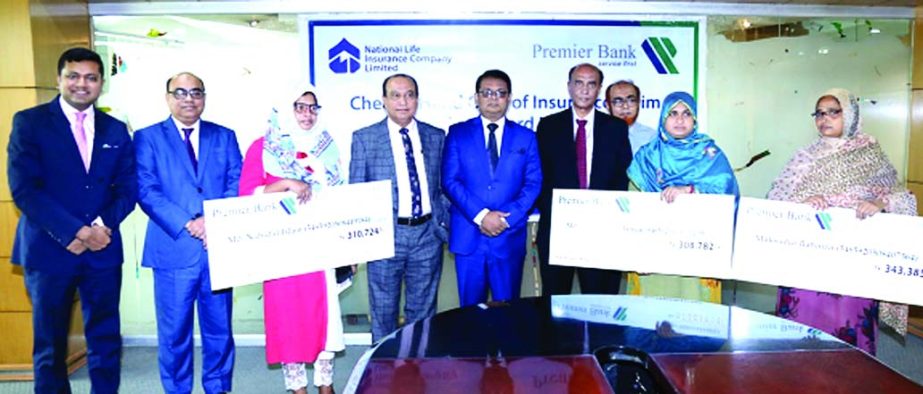 M Reazul Karim, Managing Director and CEO of the Premier Bank Ltd and Jamal M A Naser, Chief Executive Officer, National Life Ins Co Ltd, pose for photograph after handing over insurance claim cheque to legal successors of FR Tower victims at the bank's