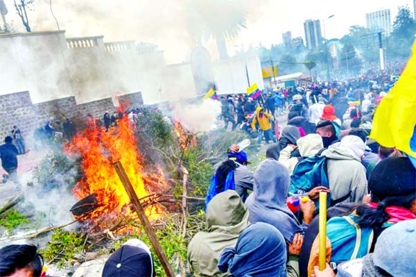 Demonstrators burn branches and tires outside the Congress building in Quito during clashes with security forces.