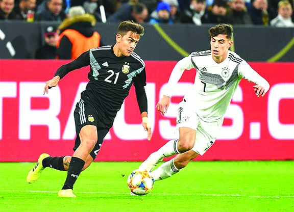 Paulo Dybala (left) of Argentina, vies with Kai Havertz of Germany, during an international friendly soccer match between Germany and Argentina, in Dortmund, Germany on Wednesday.