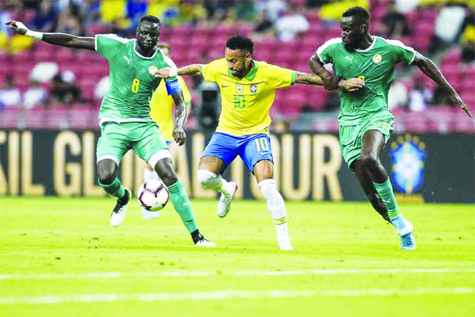 Brazil forward Neymar (center) attempts to control the ball during the FIFA international friendly match between Brazil and Senegal in Singapore on Thursday.
