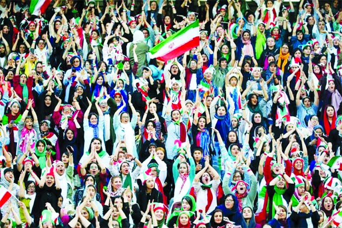 Iranian women with their country's flag at the Azadi Stadium for the 2022 World Cup qualifier soccer match between Iran and Cambodia, in Tehran, Iran on Thursday. Iranian women were freely allowed into the stadium for the first time in decades.