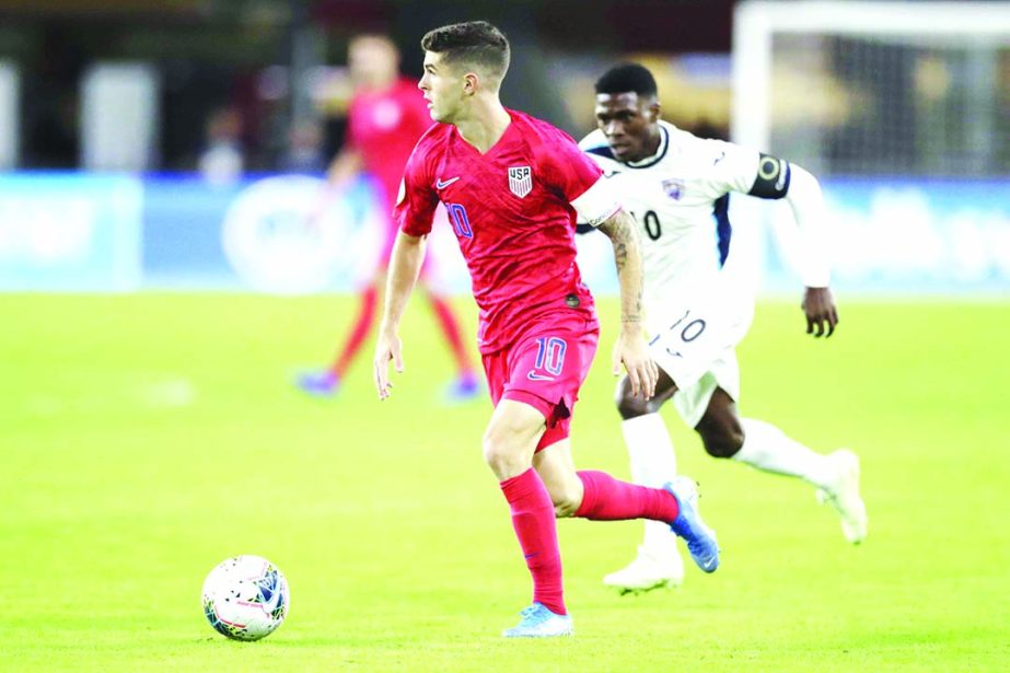 United States' Christian Pulisic (front) runs with the ball as Cuba's Aricheell Hernandez chases him during the second half of a CONCACAF Nations League soccer match in Washington on Friday.