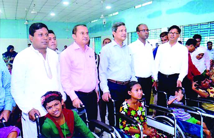 Abu Hena Md. Rahmatul Muneem, Senior Secretary of Energy and Mineral Resources Division and Chairman of Bangladesh Gas Fields Company Limited (BGFCL), distributing wheel chair among the physically challenged people at Sirajgong recently.