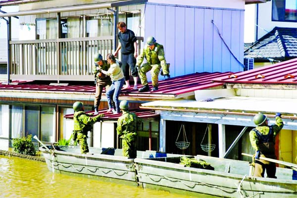 Local residents are rescued by Japanese Defence-Force soldiers from a flooded area caused by Typhoon Hagibis in Kakuda, Miyagi prefecture in Japan on October 13, 2019, in this photo taken by Kyodo.