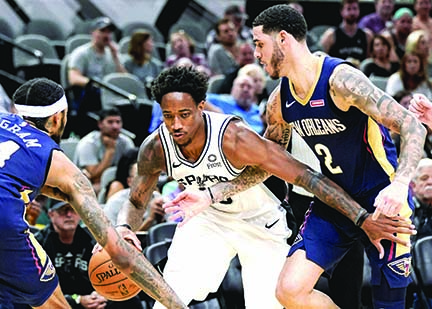 San Antonio Spurs' DeMar DeRozan( center) drives between New Orleans Pelicans' Brandon Ingram( left) and Lonzo Ball during the second half of an NBA preseason basketball game in San Antonio on Sunday.