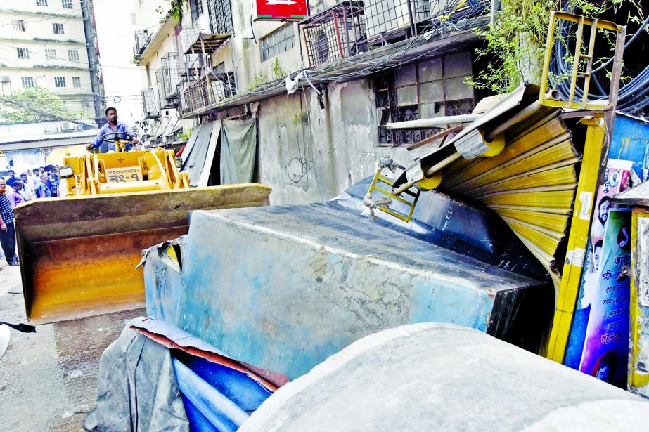 Illegal structures in the city's Motijheel area being bulldozed as part of the ongoing drive by DSCC on Tuesday.