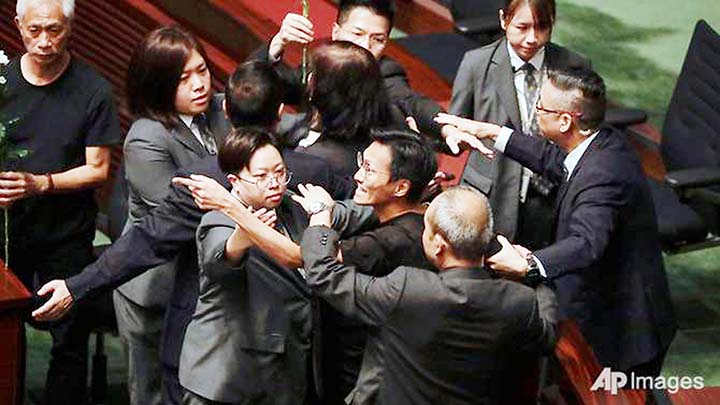 Pro-democracy lawmakers are restrained by security officials as Hong Kong Chief Executive Carrie Lam attends a question and answer session at the chamber of the Legislative Council in Hong Kong