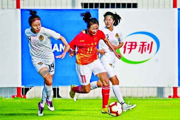 Yang Li (centre) of China, dribbles the ball during a women's football first round match between China and South Korea at the 7th International Military Sports Council (CISM) Military World Games in Wuhan, capital of central China's Hubei Province on Th