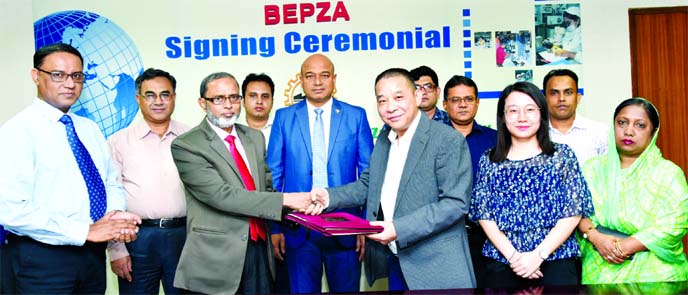 Zillur Rahman, Member (Investment Promotion) of Bangladesh Export Processing Zones Authority (BEPZA) and Mo Jisheng, Chairman of Ms. Yifa Jute & Sisal Products Company Limited (China), exchanging documents after an agreement at BEPZA office in the city o
