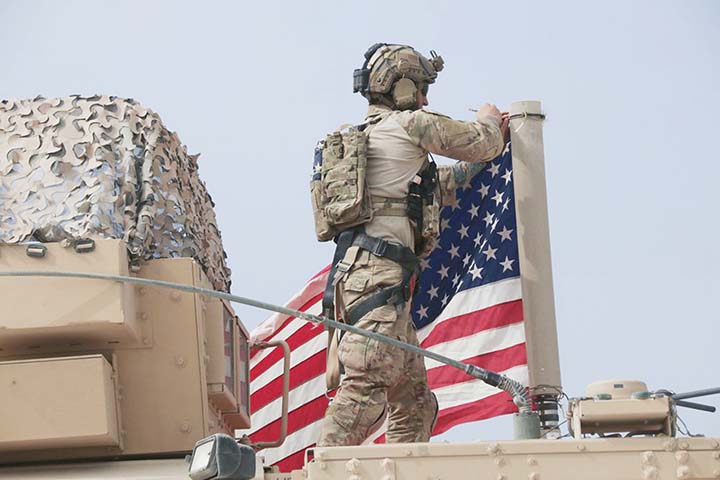 American soldier mount the U.S. flag on a vehicle near the town of Tel Tamr, north Syria on Sunday.