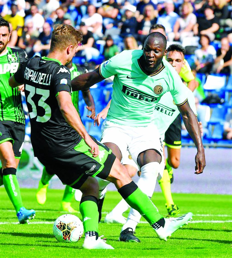 Inter Milan's Romelu Lukaku (right) vies with Sassuolo's Alessandro Tripaldelli (left) during a Serie A soccer match between Sassuolo and Inter Milan in Reggio Emilia, Italy on Sunday.