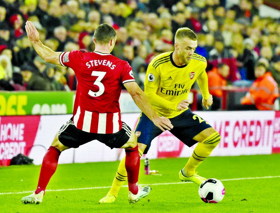 Arsenal's Calum Chambers (right) and Sheffield United's Enda Stevens challenge for the ball during the English Premier League soccer match between Sheffield United and Arsenal at Bramall Lane in Sheffield, England on Monday.