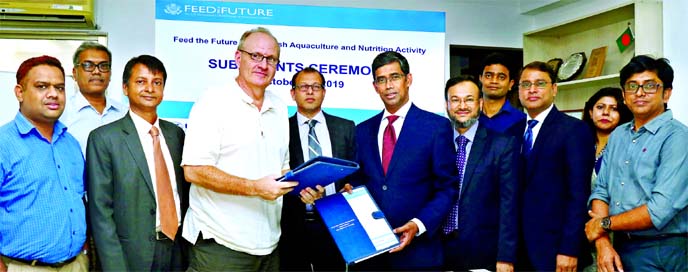 Md. Arfan Ali, Managing Director of Bank Asia Limited and Jon Thiele, Chief of Feed the Future Bangladesh Aquaculture & Nutrition Activity of the WorldFish, exchanging documents after signing a MoU on financial package for smallholders involved fish farmi