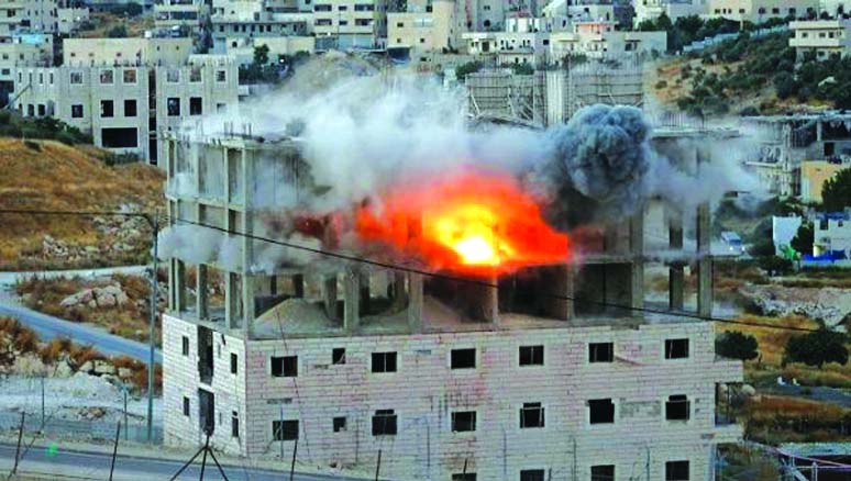 A Palestinian building is blown up by Israeli forces in the village of Sur Baher next to the Israeli barrier in East Jerusalem and the Israeli-occupied West Bank on Tuesday.