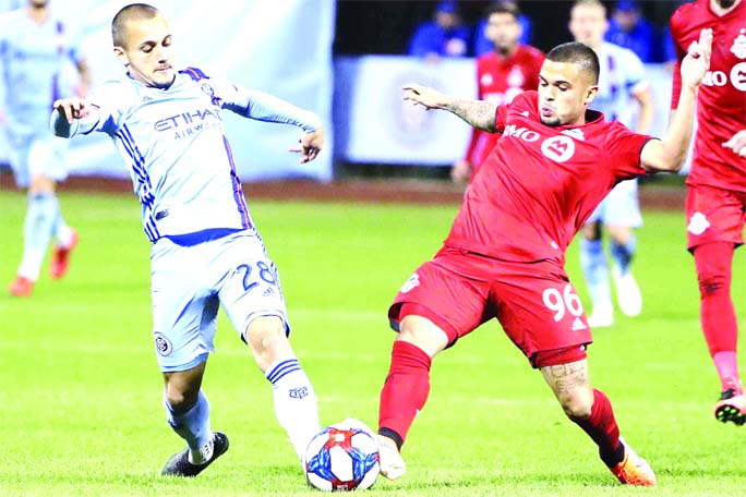 New York City FC's Alexandru Mitrita (28) fights for control of the ball with Toronto FC's Auro (96) during the second half of an MLS Eastern Conference semifinal soccer match in New York on Wednesday. Toronto won 2-1.