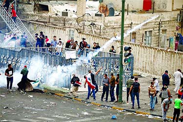 A demonstrator throws a tear gas canister during a protest over corruption, lack of jobs, and poor services, in Baghdad. Internet photo