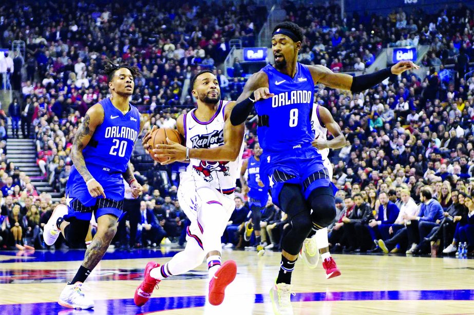 Toronto Raptors guard Norman Powell (24) drives between Orlando Magic guards Markelle Fultz (20) and Terrence Ross (8) during first-half NBA basketball game action in Toronto on Monday.