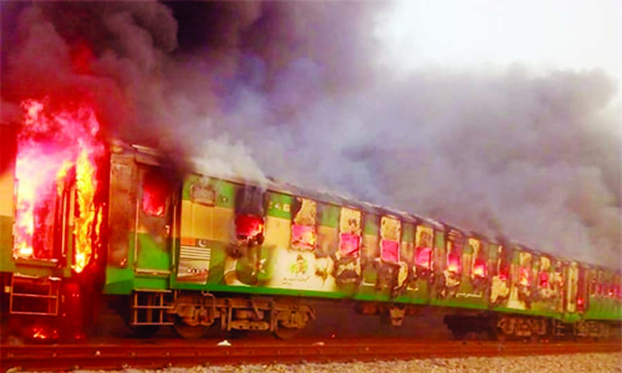 A fire burns a train carriage after a gas canister passengers were using to cook breakfast exploded, near the town of Rahim Yar Khan in the south of Punjab province, Pakistan on Thursday. Internet photo