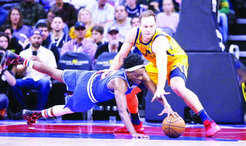 Sacramento Kings guard De'Aaron Fox (left) dives for the ball next to Utah Jazz forward Bojan Bogdanovic during the second half of an NBA basketball game in Sacramento, Calif. on Friday. The Kings won 102-101.