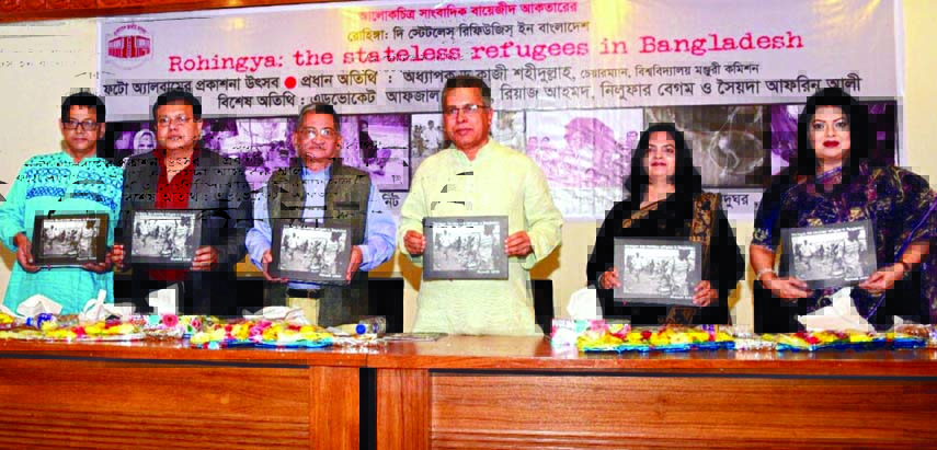 UGC Chairman Prof Dr Kazi Shahidullah along with others holds the photo album on 'Rohingya: The Stateless Refugees in Bangladesh' by photo journalist Bayazid Akhter at its cover unwrapping ceremony in Poet Sufia Kamal Auditorium of the National Museum i