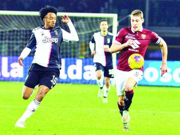 Torino's Andrea Belotti (right) and Juventus' Juan Cuadrado (left) in action during the Italian Serie A soccer match between Torino FC and Juventus FC at the Olimpico Grande Torino stadium in Turin, Italy on Saturday.